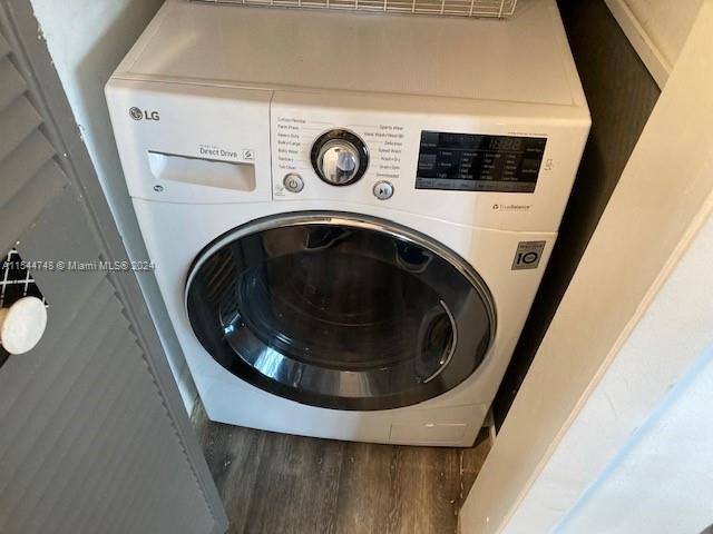 clothes washing area with wood-type flooring and washer / clothes dryer