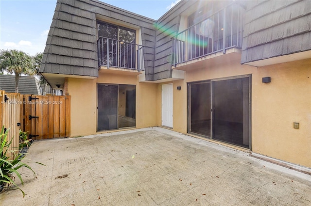 rear view of property with a balcony and a patio