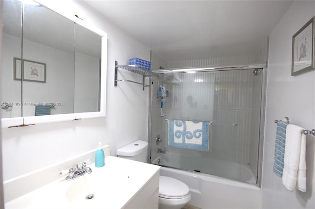 full bathroom with enclosed tub / shower combo, toilet, and vanity