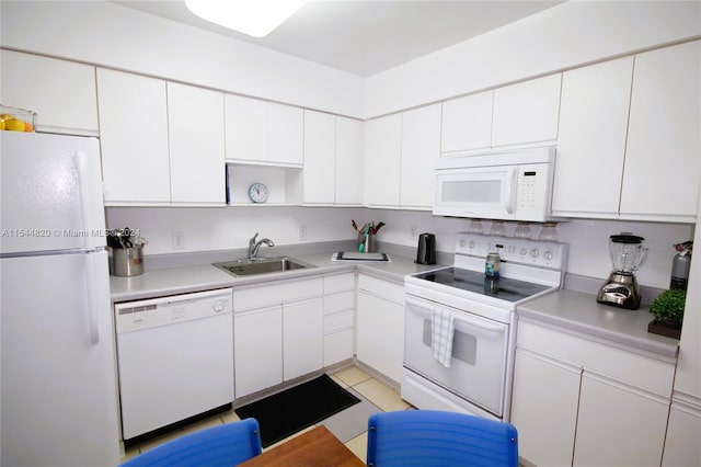 kitchen featuring white appliances, white cabinetry, sink, and light tile flooring