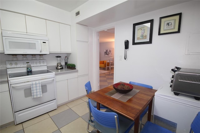 kitchen featuring white appliances, white cabinetry, and light tile floors