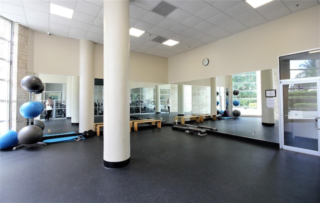 exercise room featuring a high ceiling and a paneled ceiling