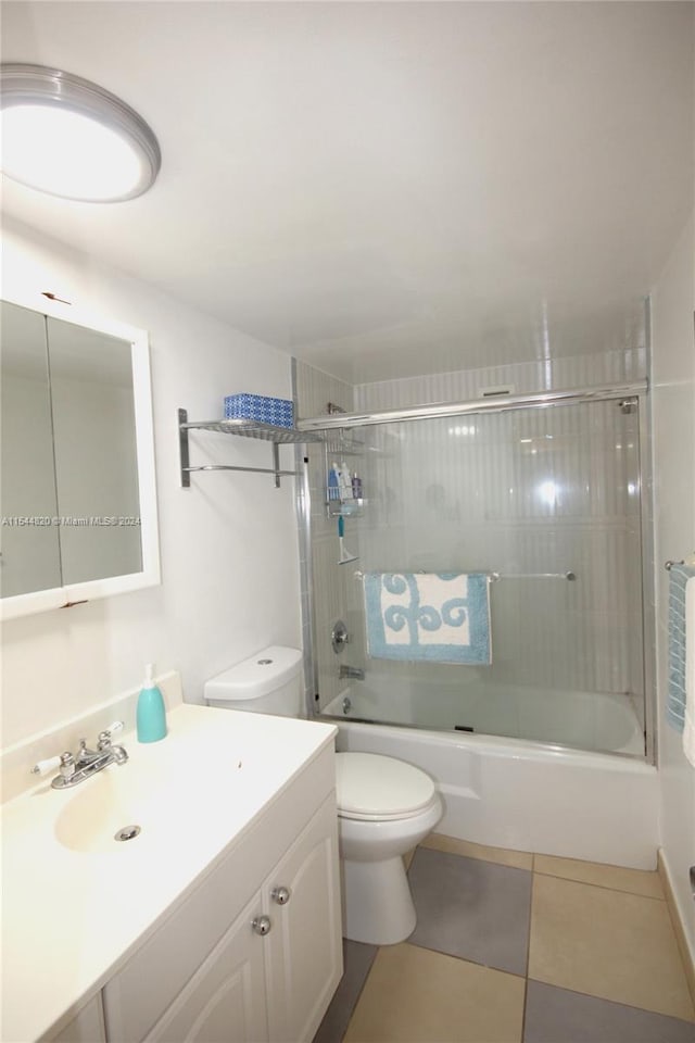 full bathroom with vanity, shower / bath combination with glass door, tile flooring, and toilet