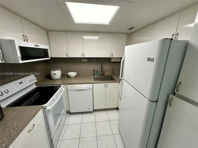 kitchen featuring backsplash, white appliances, white cabinetry, and sink