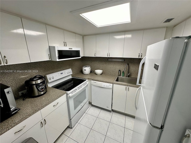 kitchen with backsplash, white appliances, white cabinetry, and sink