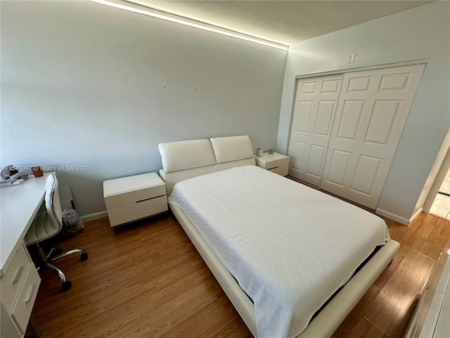 bedroom with a closet and hardwood / wood-style flooring