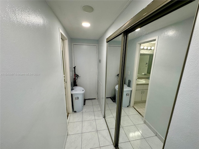 corridor featuring light tile floors and sink