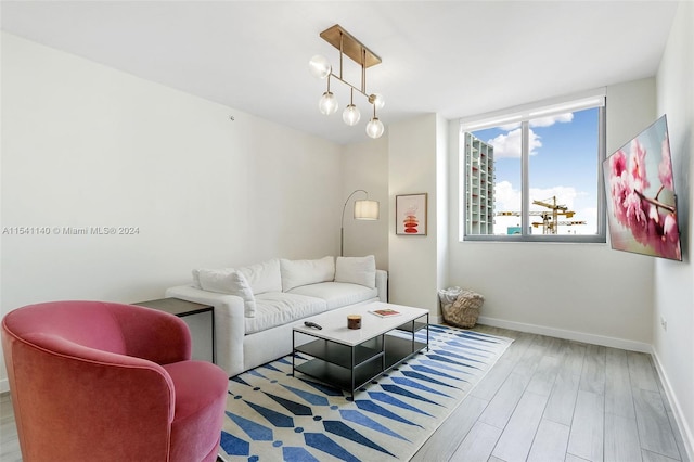 living room with a notable chandelier and light hardwood / wood-style flooring