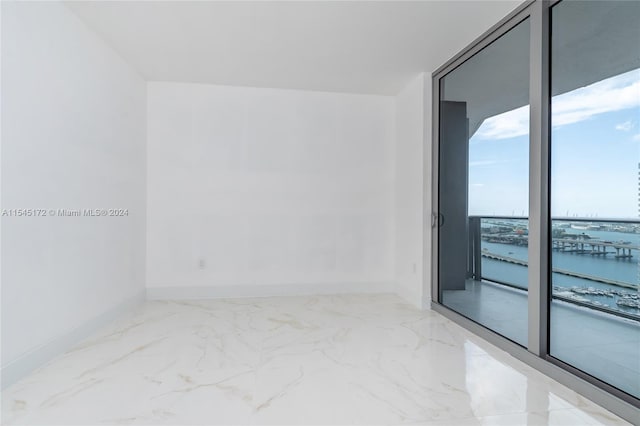 empty room featuring expansive windows and a water view