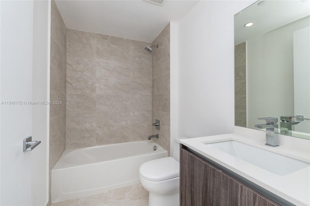 full bathroom with tile patterned floors, vanity, tiled shower / bath combo, and toilet