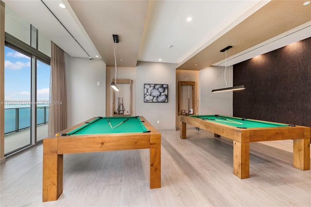 game room featuring a water view, light hardwood / wood-style floors, and pool table