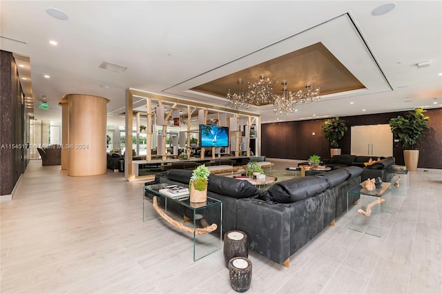 living room featuring a raised ceiling and light hardwood / wood-style floors