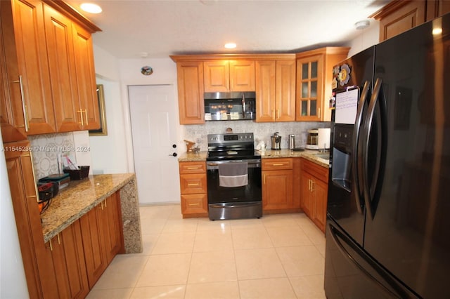 kitchen featuring light stone counters, light tile patterned floors, backsplash, and appliances with stainless steel finishes