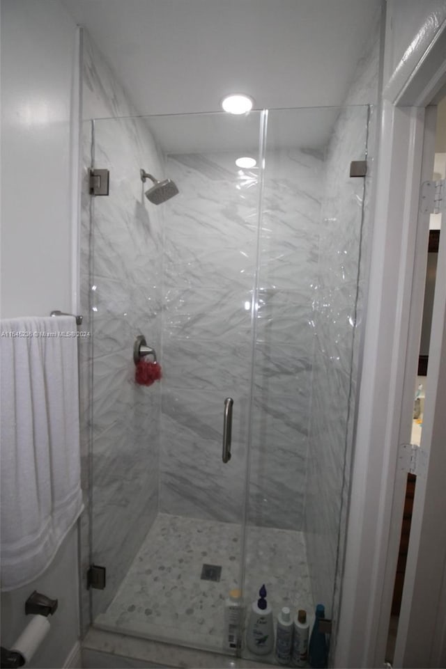 bathroom with a shower with door