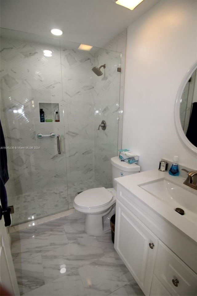 bathroom with toilet, vanity, and walk in shower