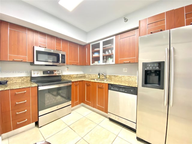 kitchen featuring sink, light stone counters, light tile flooring, and stainless steel appliances