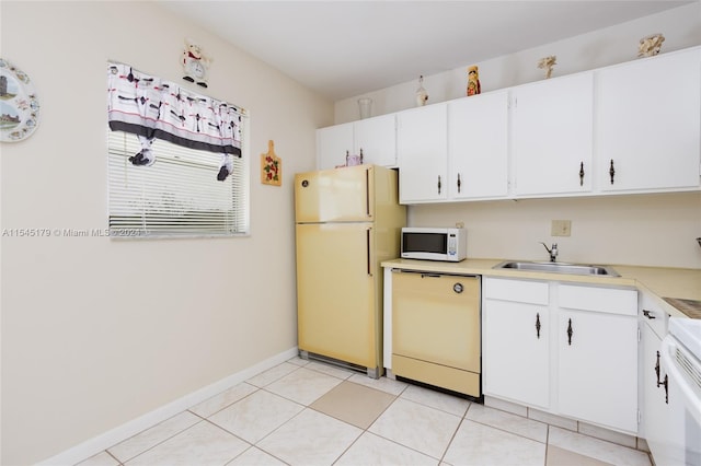 kitchen with white appliances, white cabinets, light tile floors, and sink