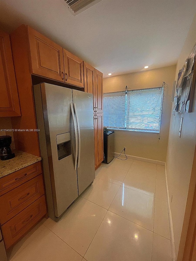 kitchen featuring stainless steel fridge and light tile patterned flooring