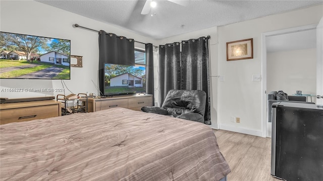 bedroom featuring ceiling fan, light hardwood / wood-style floors, and a textured ceiling