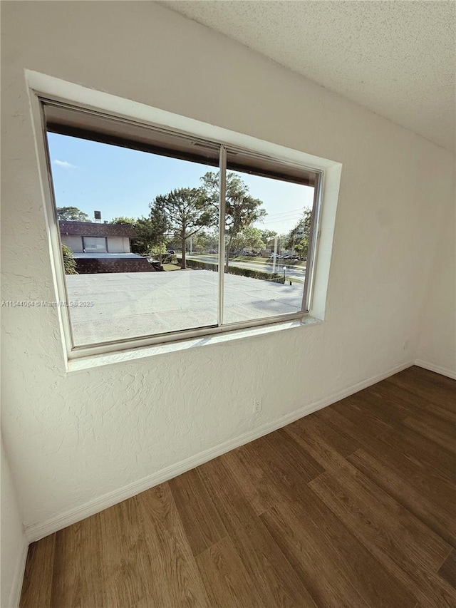 spare room featuring hardwood / wood-style flooring and a textured ceiling