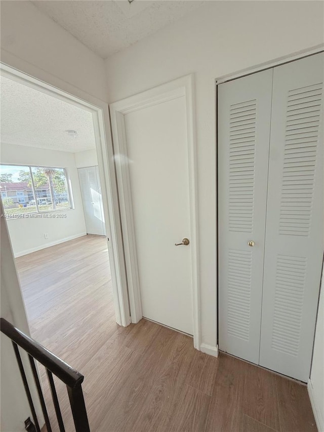 hall featuring hardwood / wood-style floors and a textured ceiling