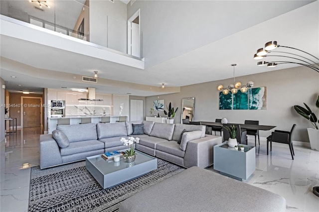 tiled living room with a notable chandelier and a towering ceiling