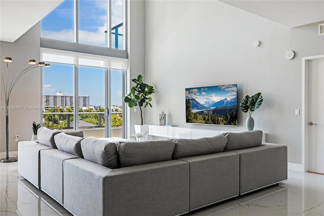 tiled living room featuring a towering ceiling and a wealth of natural light