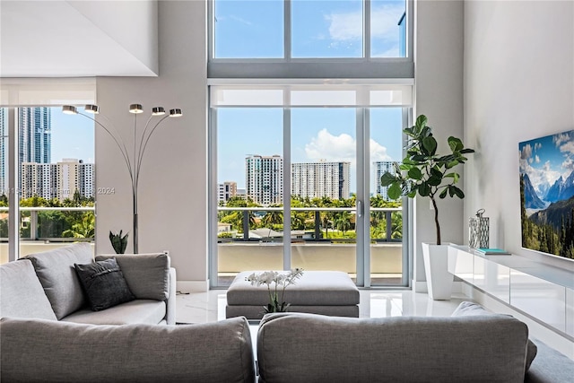 living room with a high ceiling and light tile flooring