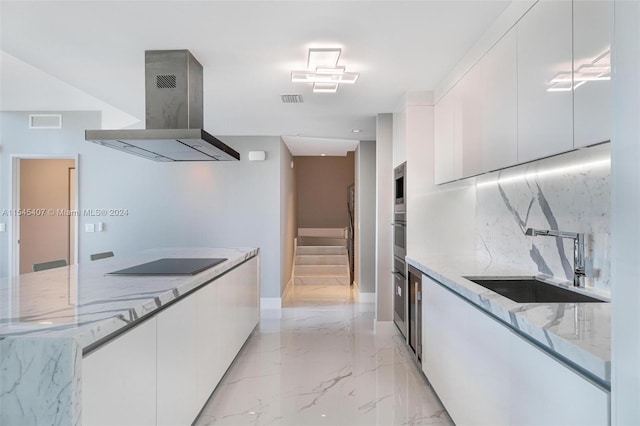 kitchen featuring light tile flooring, sink, white cabinetry, and wall chimney range hood