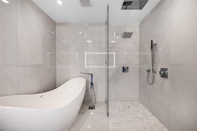 bathroom featuring tile walls, tile flooring, and separate shower and tub