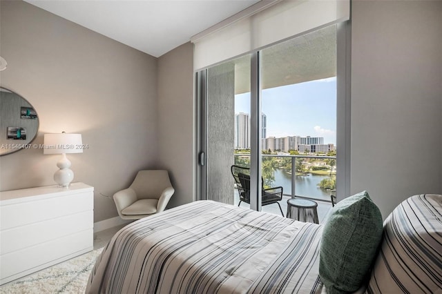 bedroom featuring carpet flooring, access to outside, and a water view