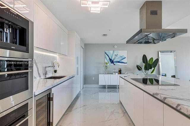 kitchen with white cabinetry, sink, light tile floors, and island range hood