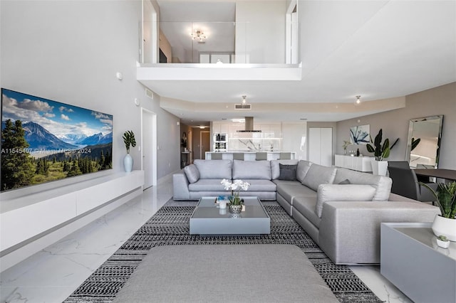 living room featuring light tile floors and a towering ceiling