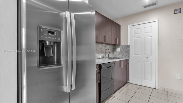 kitchen with light tile patterned floors, dishwasher, sink, stainless steel refrigerator with ice dispenser, and dark brown cabinetry