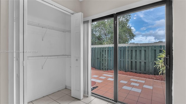 doorway to outside with light tile patterned flooring