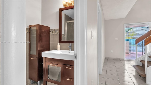 bathroom with a shower with shower door, tile patterned flooring, a textured ceiling, and vanity