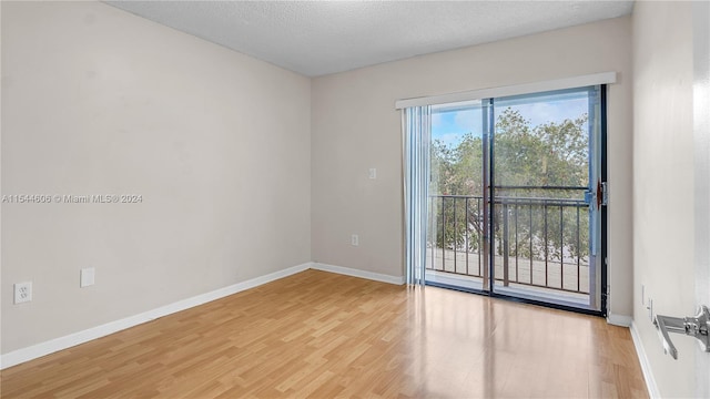 unfurnished room featuring a textured ceiling, a healthy amount of sunlight, and light hardwood / wood-style flooring