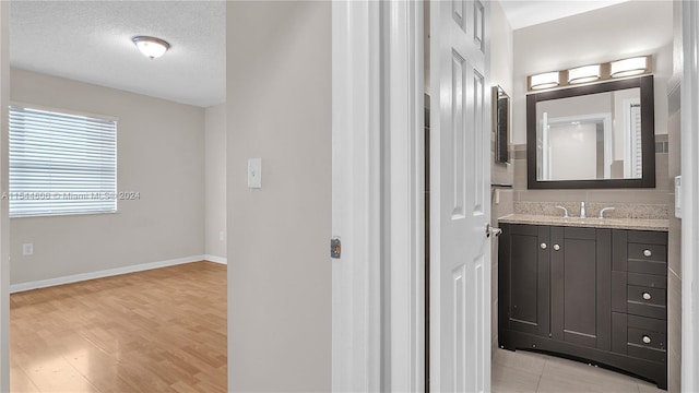 bathroom featuring wood-type flooring, a textured ceiling, and vanity