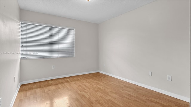 empty room featuring wood-type flooring and a textured ceiling