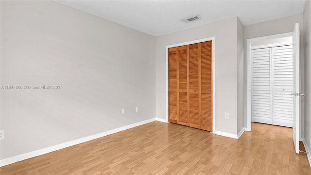 unfurnished bedroom with light hardwood / wood-style flooring and a closet