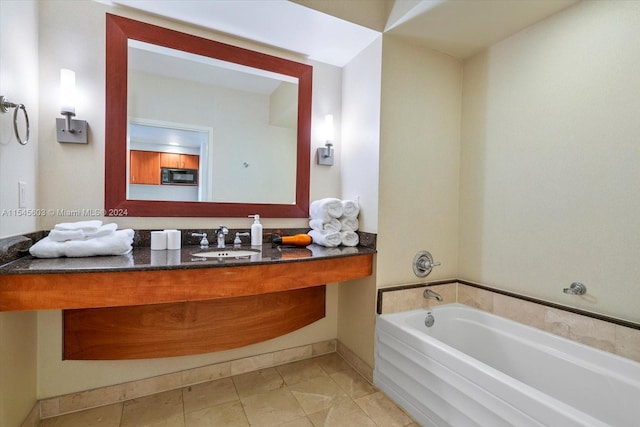 bathroom featuring a bath, vanity with extensive cabinet space, and tile flooring