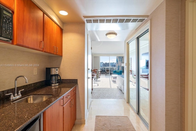 kitchen featuring light carpet, sink, and dark stone counters