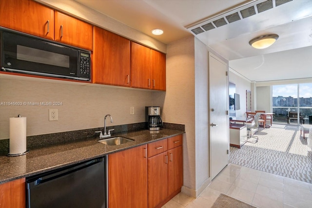 kitchen featuring light colored carpet, sink, dark stone counters, dishwashing machine, and black microwave