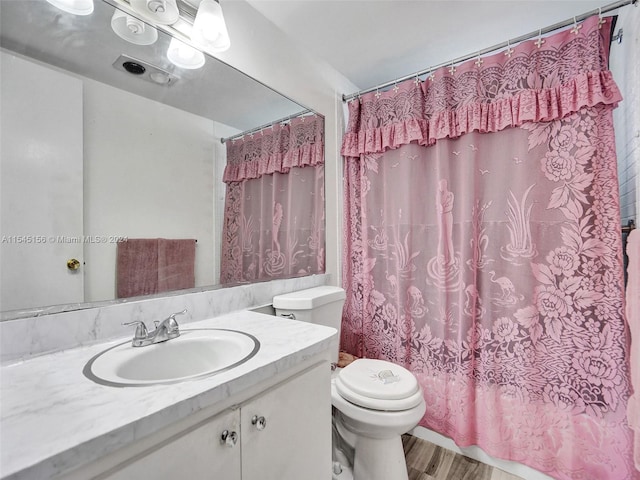 bathroom with vanity, hardwood / wood-style floors, a shower with curtain, and toilet