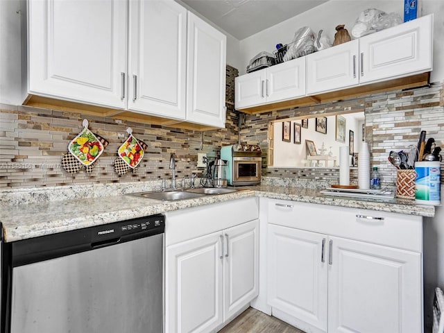 kitchen featuring white cabinetry, stainless steel dishwasher, and backsplash