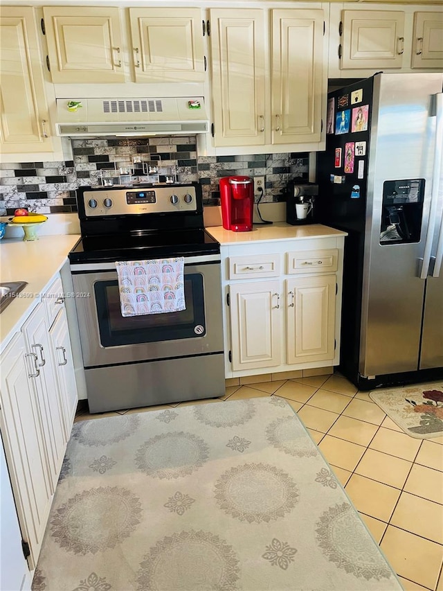 kitchen featuring stainless steel appliances, light tile floors, premium range hood, and backsplash