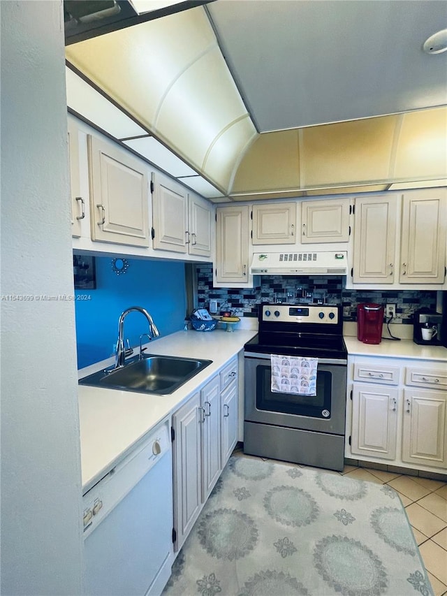 kitchen with electric stove, backsplash, sink, dishwasher, and light tile floors