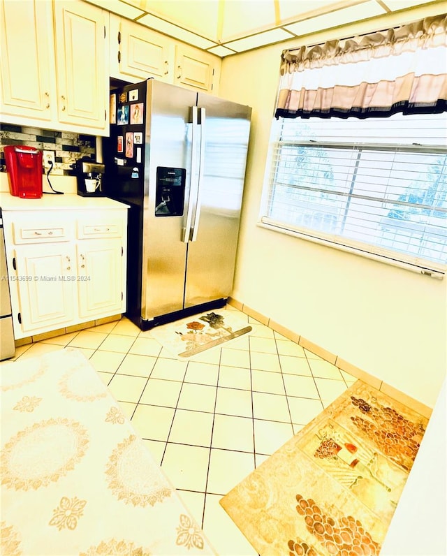 kitchen featuring backsplash, stainless steel fridge, and light tile floors