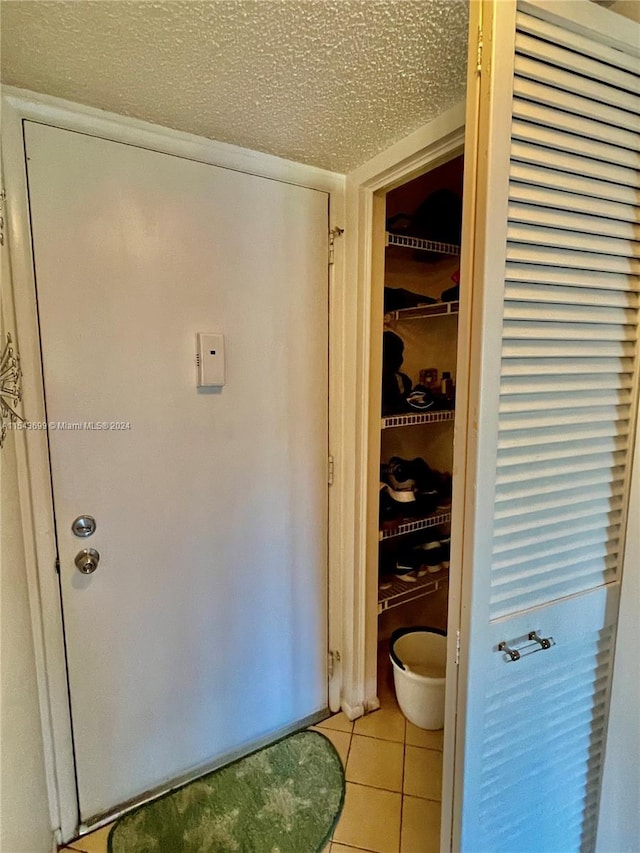 bathroom with tile floors and a textured ceiling