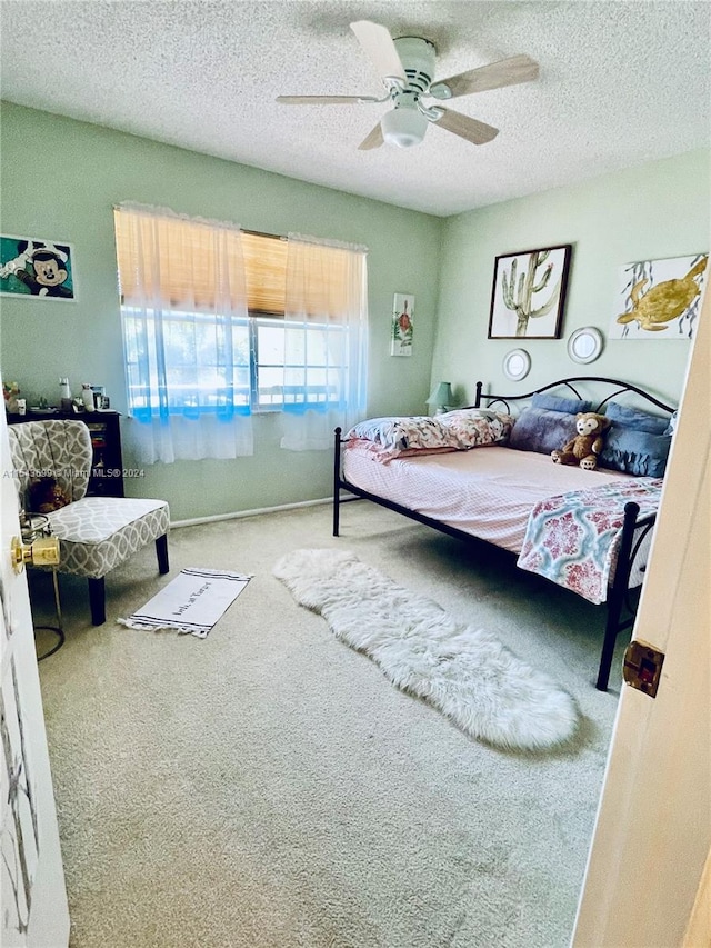 bedroom featuring a textured ceiling, ceiling fan, and carpet floors